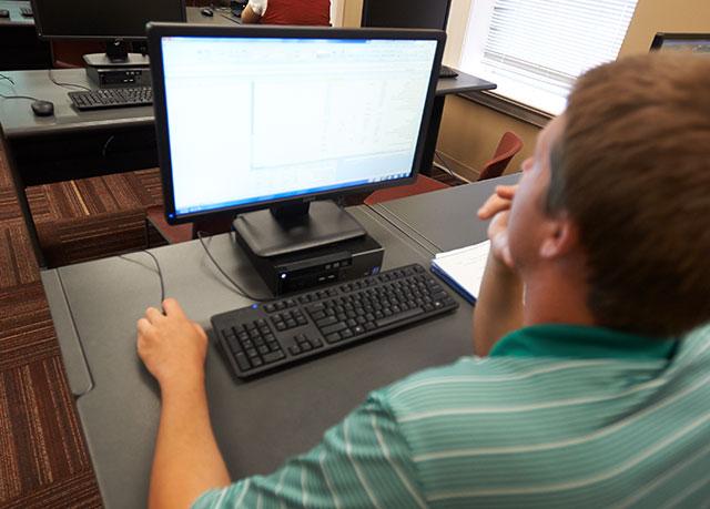 A student sits at a laptop